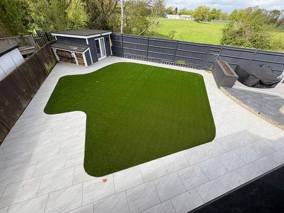 Aerial view of an artificial lawn surrounded by pale porcelain paving